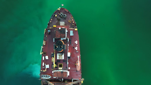 Nadir photo of freighter stern deck taken at dusk, resulting in a blurry photo due to the drone camera having a rolling shutter, low light and too fast of flight speed.